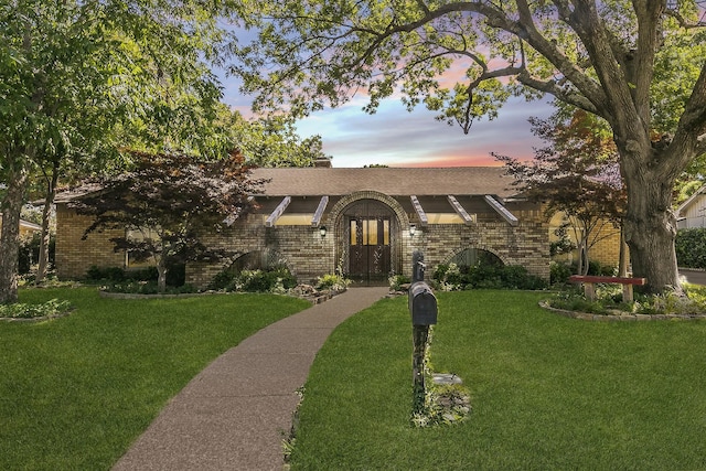 view of front of home featuring a lawn and french doors