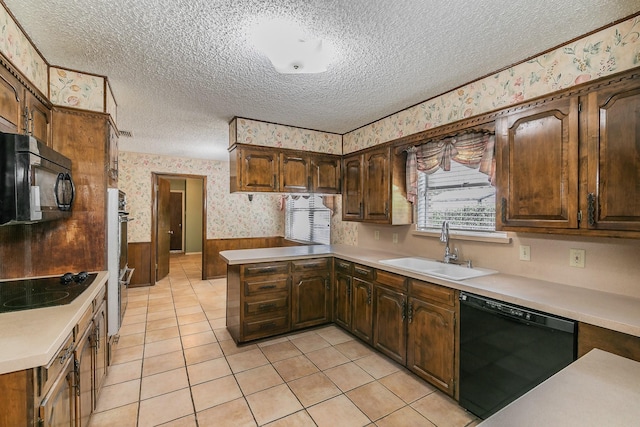 kitchen with sink, light tile patterned floors, black appliances, and a textured ceiling