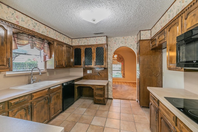 kitchen featuring sink, black appliances, a textured ceiling, and light tile patterned flooring