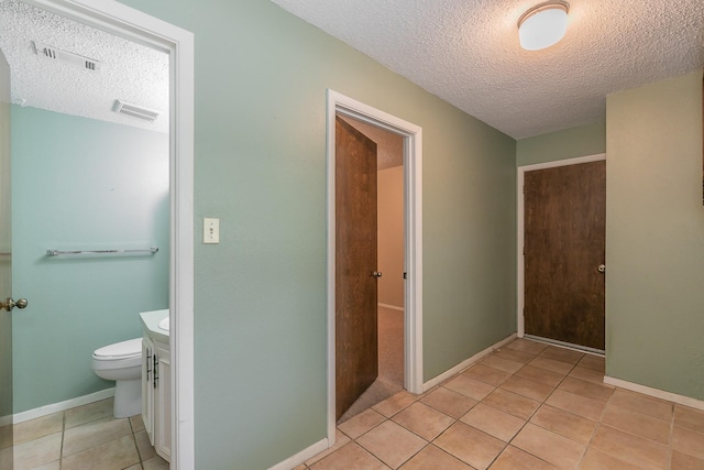 hallway with light tile patterned flooring and a textured ceiling