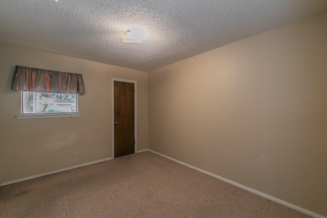 carpeted spare room with a textured ceiling