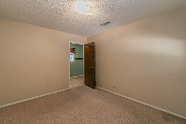 carpeted empty room with a textured ceiling