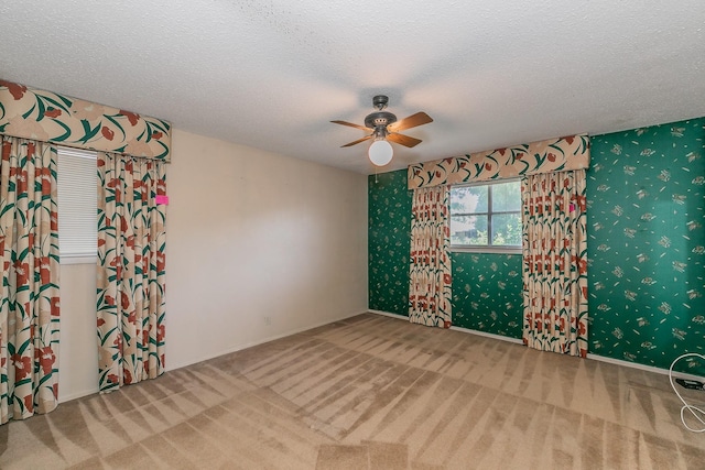 carpeted spare room with ceiling fan and a textured ceiling