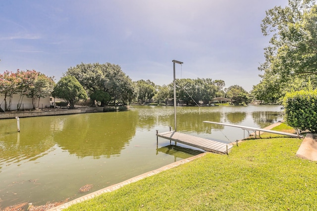 dock area with a water view and a lawn