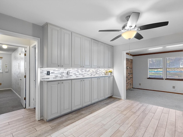 kitchen featuring decorative backsplash, ceiling fan, and light hardwood / wood-style flooring