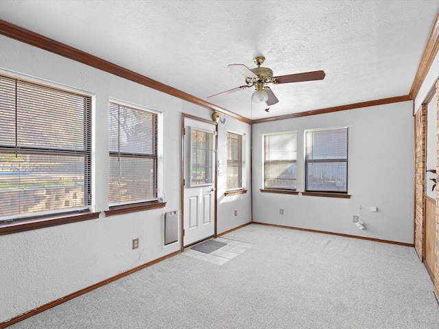 unfurnished bedroom featuring a textured ceiling, light colored carpet, ceiling fan, and crown molding