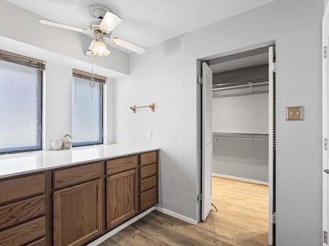 bathroom featuring ceiling fan, hardwood / wood-style floors, and a textured ceiling