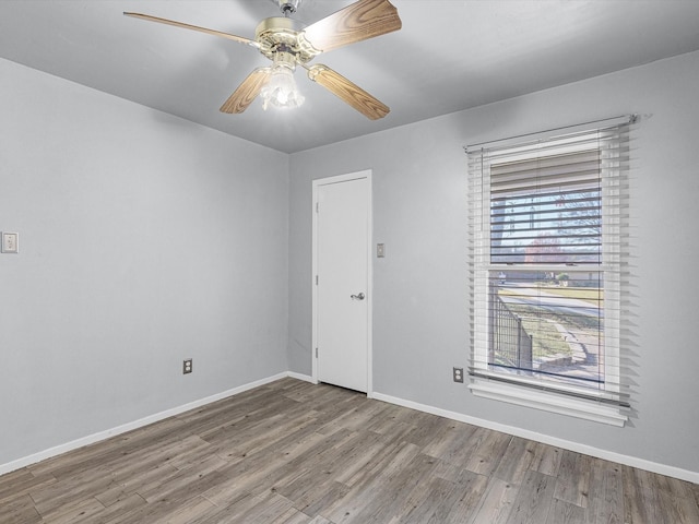 spare room featuring ceiling fan, plenty of natural light, and hardwood / wood-style flooring