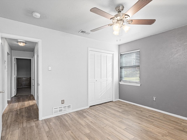 unfurnished bedroom with ceiling fan, a closet, and light hardwood / wood-style floors