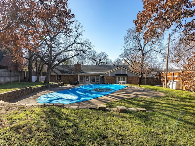 view of swimming pool featuring a lawn and a patio area