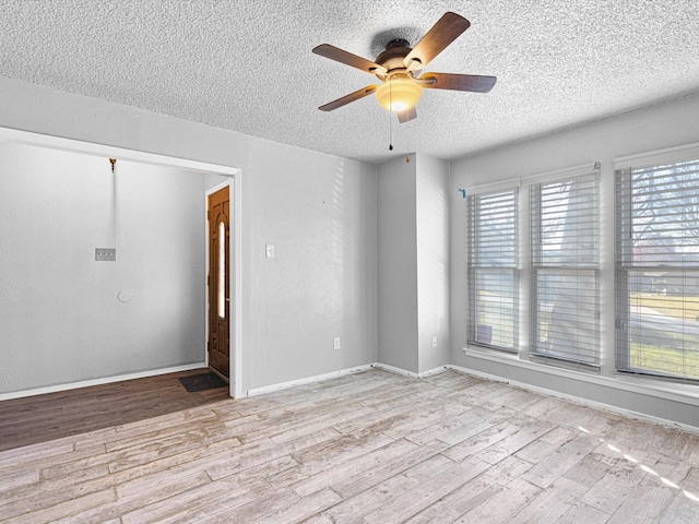 unfurnished room featuring ceiling fan, light hardwood / wood-style flooring, and a textured ceiling