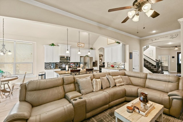 living room featuring ceiling fan and crown molding