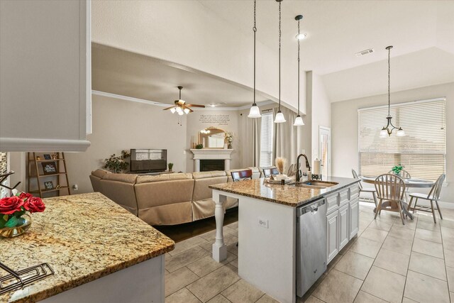 kitchen featuring a kitchen island with sink, stainless steel dishwasher, light stone countertops, decorative light fixtures, and white cabinetry