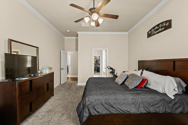 bedroom featuring carpet flooring, a spacious closet, ceiling fan, crown molding, and a closet