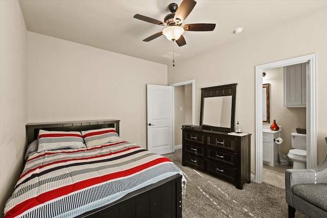 bedroom featuring light colored carpet, ensuite bath, and ceiling fan