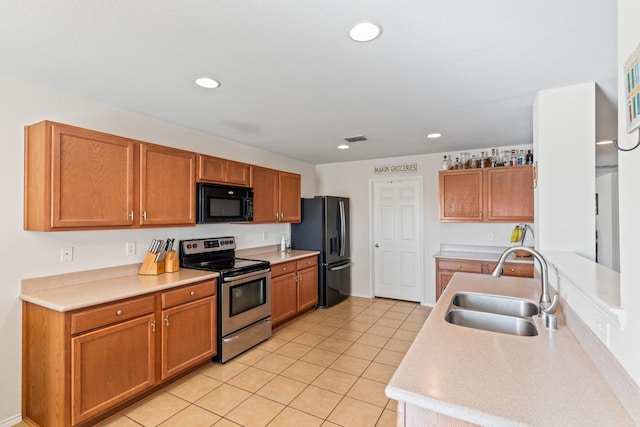 kitchen featuring black appliances, light tile patterned floors, and sink