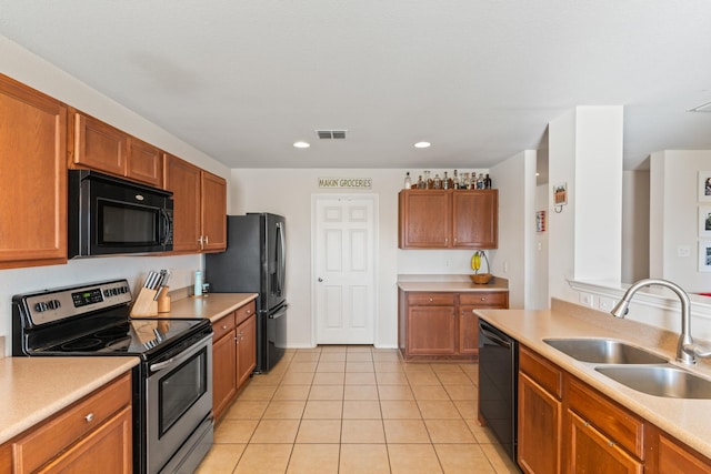 kitchen with light tile patterned floors, sink, and black appliances