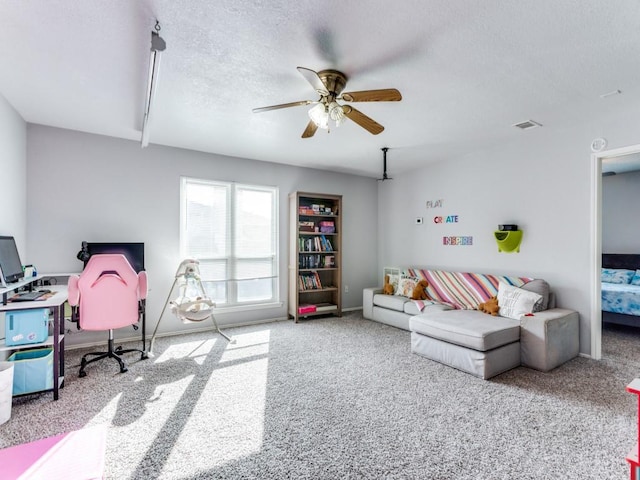 living room with beam ceiling, ceiling fan, light carpet, and a textured ceiling