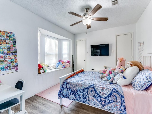 bedroom featuring wood-type flooring, a textured ceiling, and ceiling fan