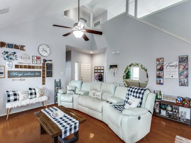 living room with ceiling fan, dark hardwood / wood-style flooring, and a towering ceiling