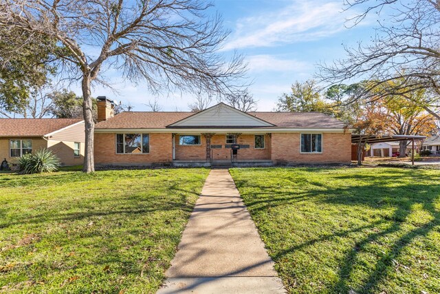 single story home featuring a front lawn and a carport