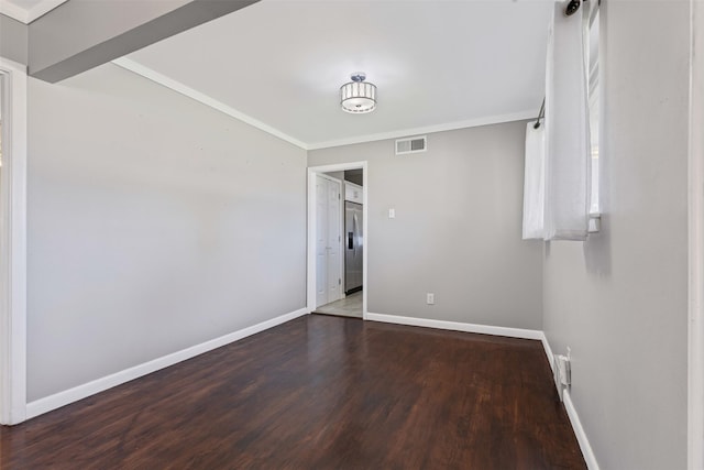 empty room with ornamental molding and dark hardwood / wood-style flooring