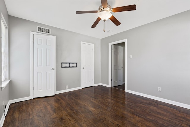 unfurnished bedroom featuring dark wood-type flooring and ceiling fan