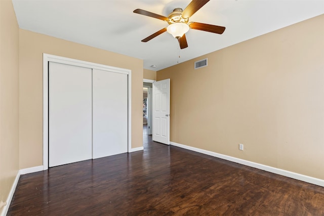 unfurnished bedroom featuring ceiling fan, dark hardwood / wood-style floors, and a closet