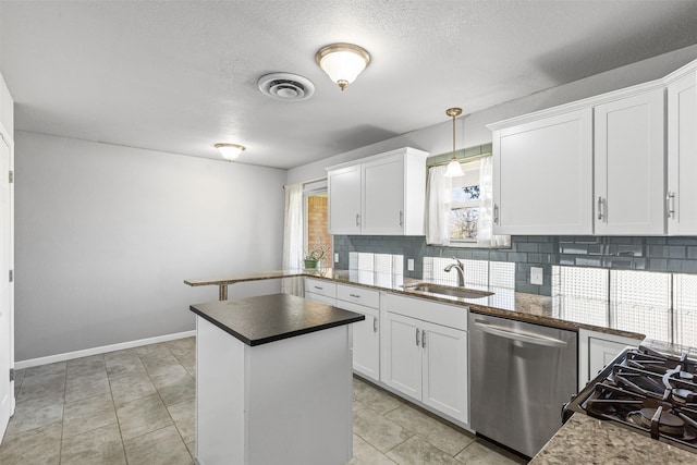 kitchen featuring sink, tasteful backsplash, white cabinets, decorative light fixtures, and stainless steel dishwasher