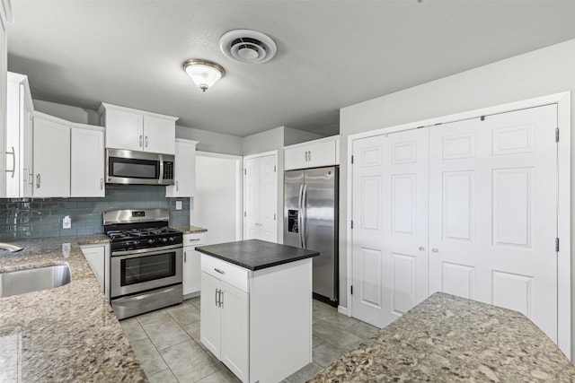 kitchen with sink, stainless steel appliances, white cabinets, and a kitchen island