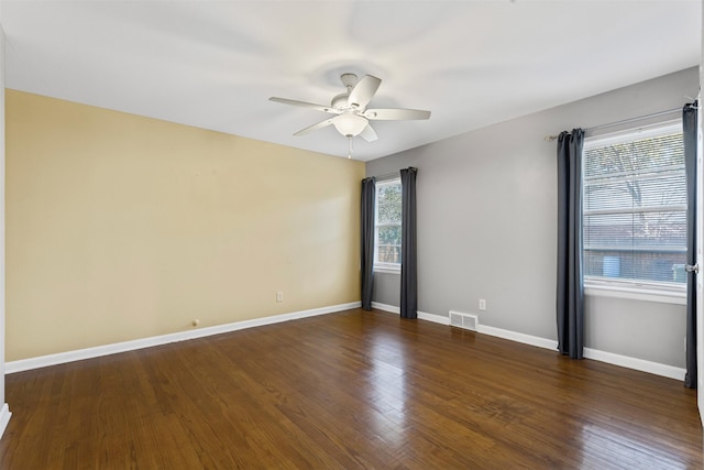 empty room featuring dark wood-type flooring and ceiling fan