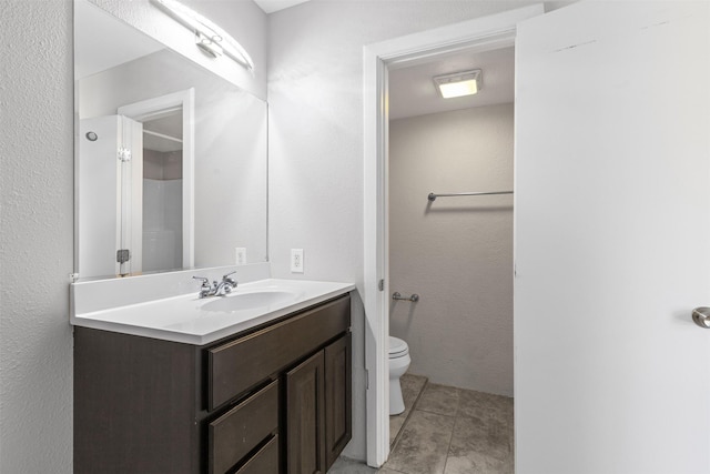 bathroom featuring tile patterned floors, vanity, and toilet