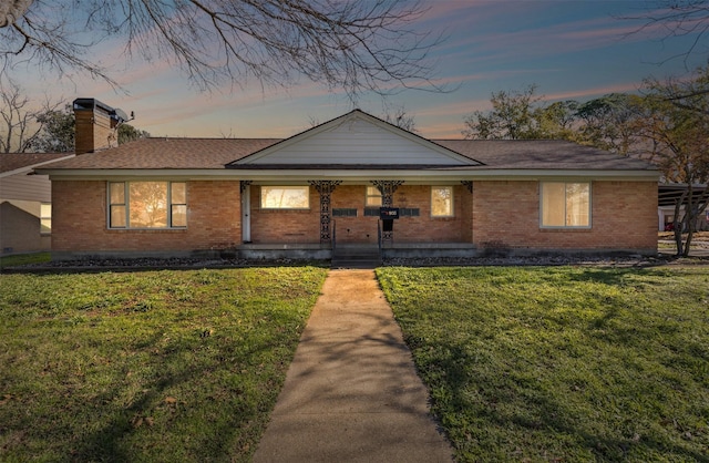 single story home featuring a lawn