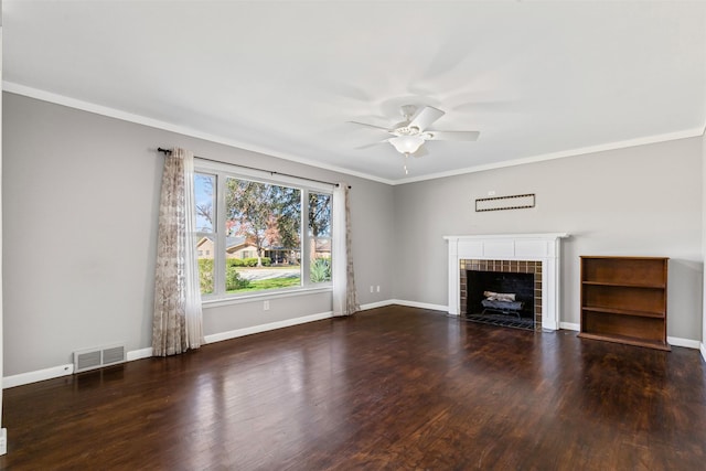 unfurnished living room featuring a tiled fireplace, crown molding, dark hardwood / wood-style floors, and ceiling fan