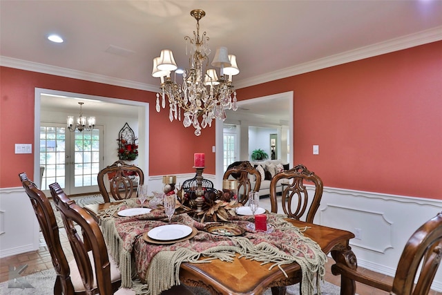 dining area featuring an inviting chandelier, ornamental molding, and french doors