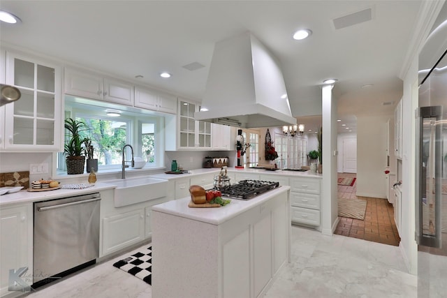 kitchen with custom exhaust hood, white cabinets, sink, appliances with stainless steel finishes, and a kitchen island