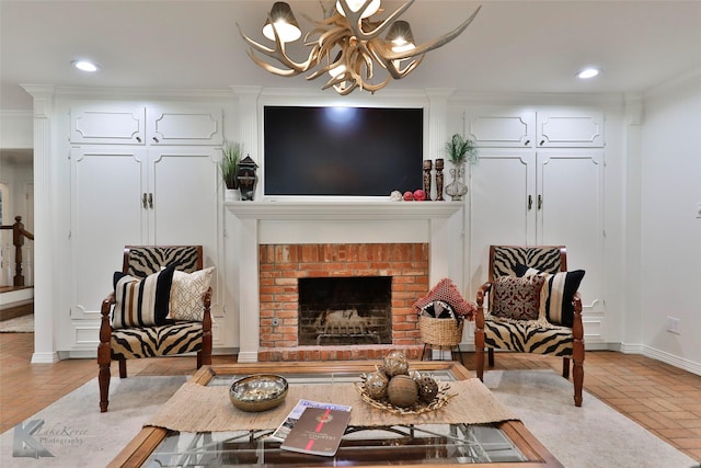 living room with an inviting chandelier, a brick fireplace, and crown molding