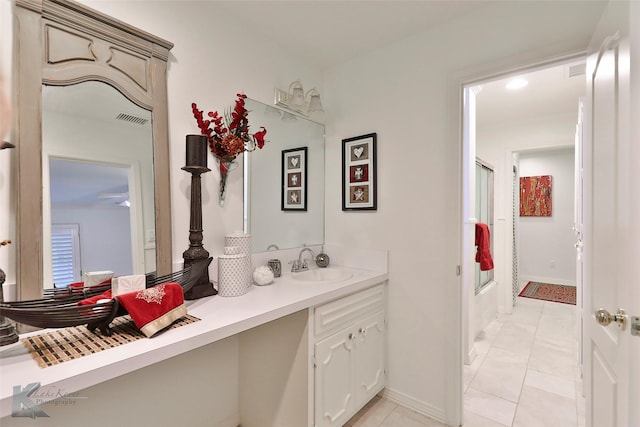 bathroom with tile patterned floors, vanity, and enclosed tub / shower combo