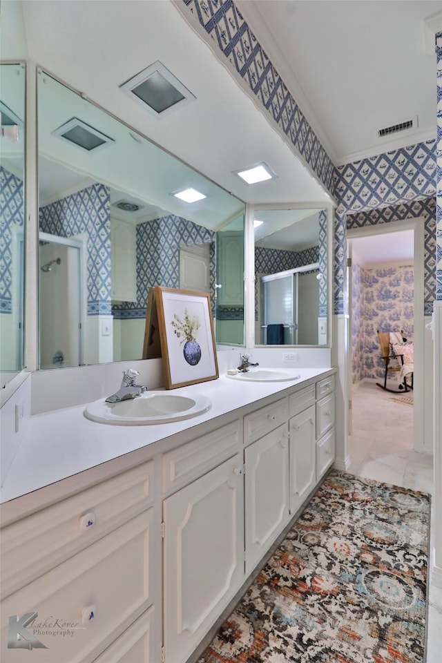 bathroom with vanity, a shower with shower door, and ornamental molding