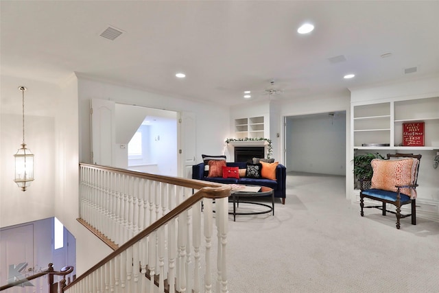 interior space featuring built in shelves and light colored carpet