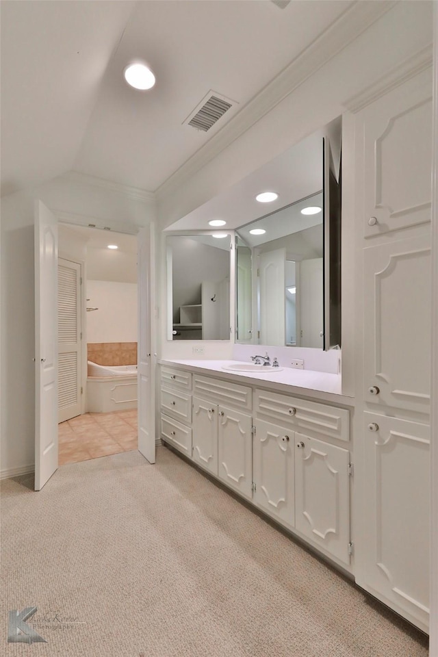 bathroom with vanity, crown molding, lofted ceiling, and a bath