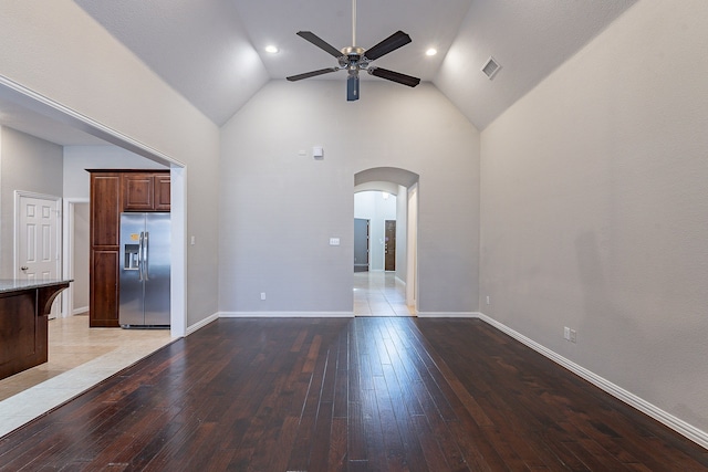 unfurnished living room featuring ceiling fan, hardwood / wood-style floors, and a high ceiling