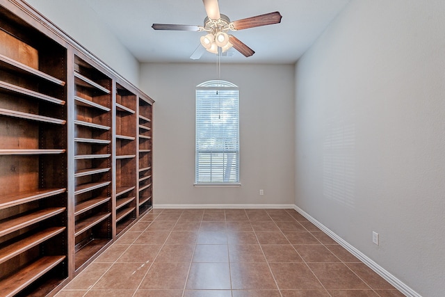 empty room with tile patterned flooring, a wealth of natural light, and ceiling fan