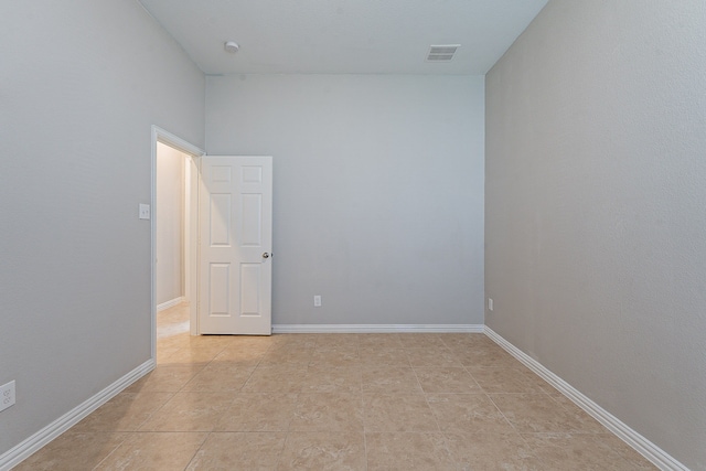 spare room with a towering ceiling and light tile patterned floors