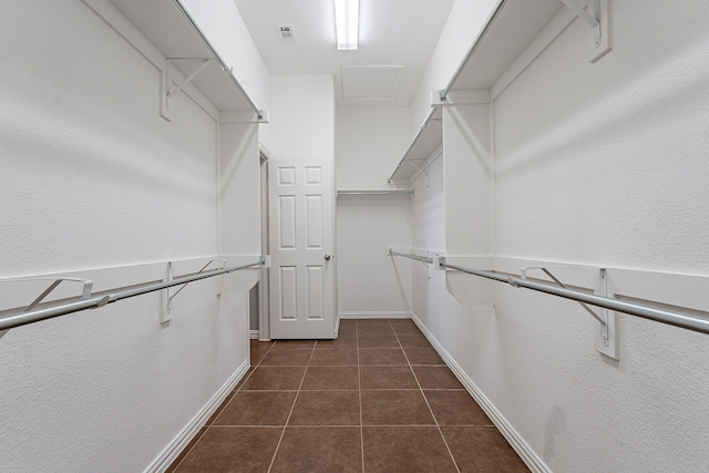 spacious closet with dark tile patterned floors