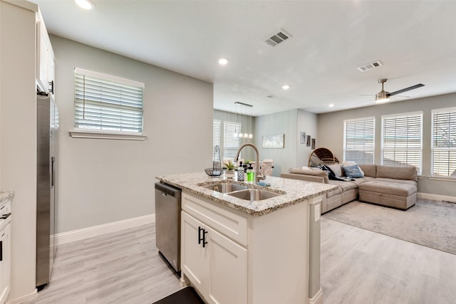 kitchen with white cabinetry, sink, a center island with sink, appliances with stainless steel finishes, and light wood-type flooring