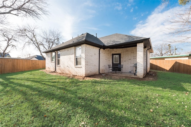 rear view of property featuring a yard and a patio