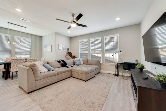 living room with ceiling fan and light hardwood / wood-style flooring