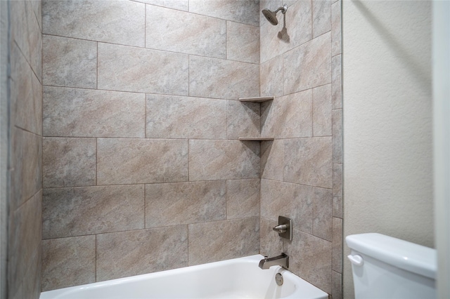 bathroom with toilet and tiled shower / bath