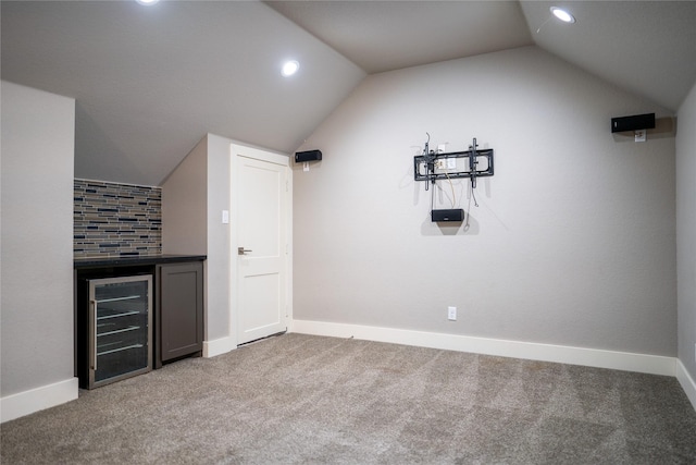 bar with carpet, beverage cooler, and vaulted ceiling